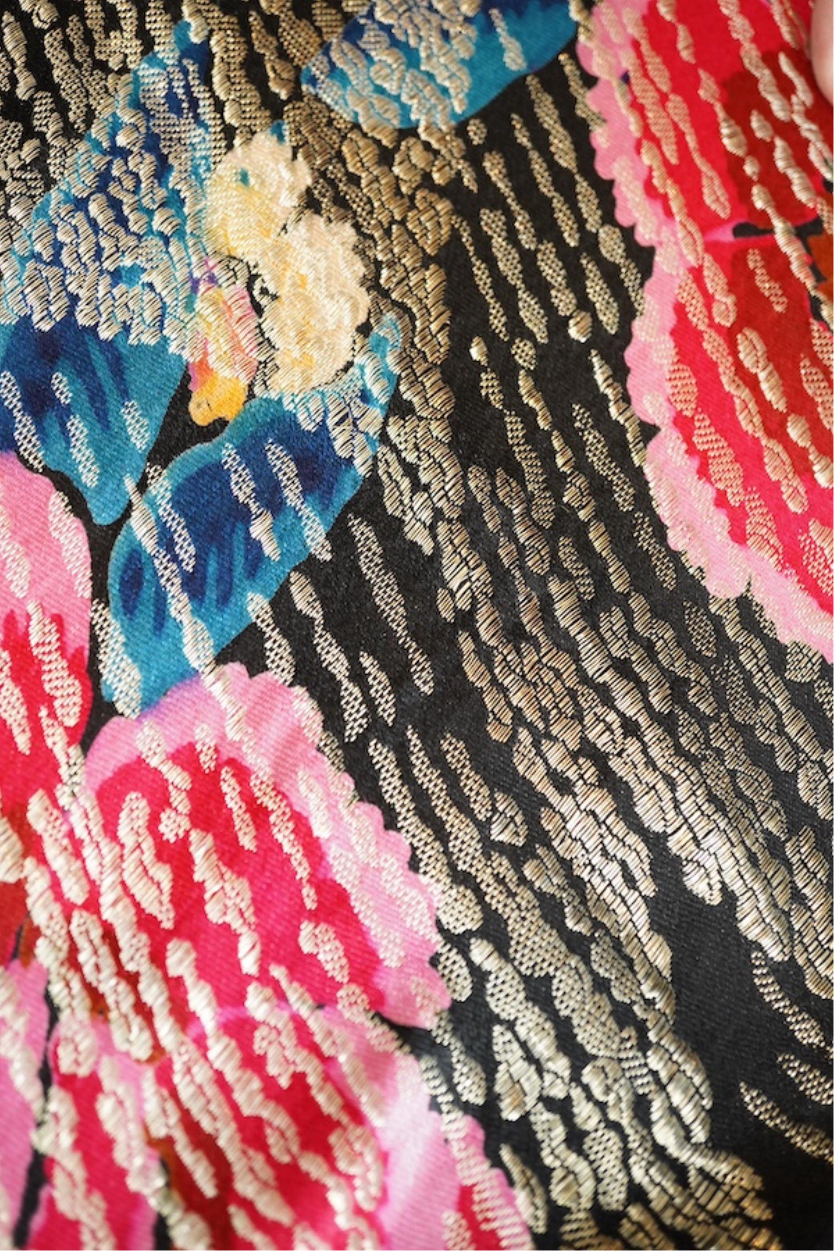 A 1930's ‘jazz age’ black and coloured silk lame evening shawl. Woven with giant pink and red roses and silver thread stripes, edged with long silk fringing. 118cm x 123cm. Condition - colours and silk strong. Fringing g